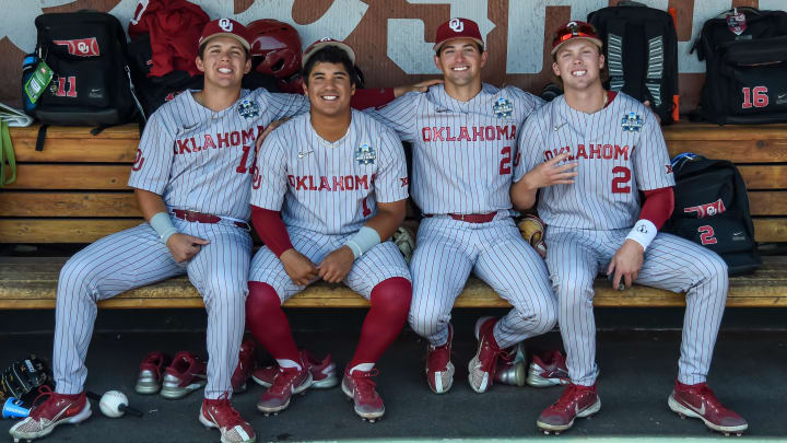 Jun 26, 2022; Omaha, NE, USA;  Oklahoma Sooners outfielder Sebastian Orduno (11) and designated hitter Diego Muniz (1) and infielder Trent Brown (2) and infielder Max McGwire (21) in the dugout before the game against the Ole Miss Rebels at Charles Schwab Field. Credit: Steven Branscombe-USA TODAY Sports