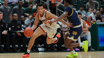 Feb 1, 2025; Coral Gables, Florida, USA; Miami Hurricanes guard Divine Ugochukwu (99) drives to the basket past Notre Dame Fighting Irish guard Markus Burton (3) during the second half at Watsco Center. Mandatory Credit: Sam Navarro-Imagn Images