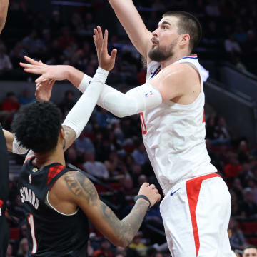 Mar 20, 2024; Portland, Oregon, USA; LA Clippers center Ivica Zubac (40) shoots the ball over Portland Trail Blazers guard Dalano Banton (5)] and Portland Trail Blazers guard Anfernee Simons (1) in the second quarter at Moda Center. Mandatory Credit: Jaime Valdez-USA TODAY Sports