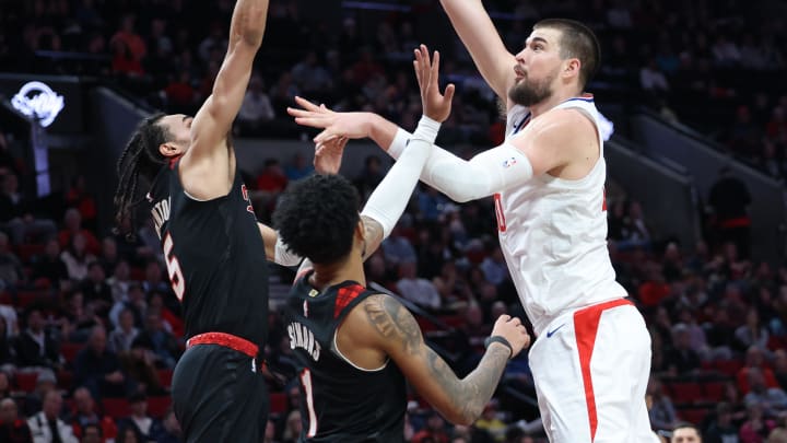 Mar 20, 2024; Portland, Oregon, USA; LA Clippers center Ivica Zubac (40) shoots the ball over Portland Trail Blazers guard Dalano Banton (5)] and Portland Trail Blazers guard Anfernee Simons (1) in the second quarter at Moda Center. Mandatory Credit: Jaime Valdez-USA TODAY Sports