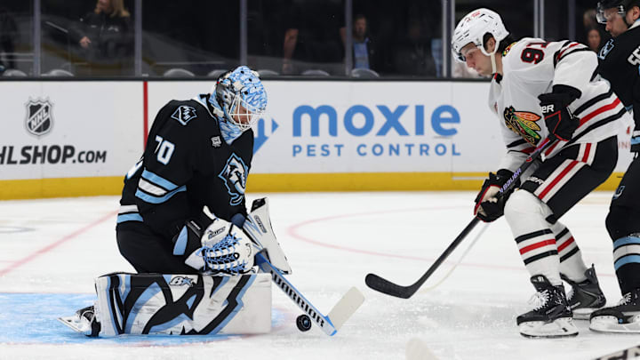 Mar 1, 2026; Salt Lake City, Utah, USA; Utah Mammoth goaltender Karel Vejmelka (70) blocks a shot as Chicago Blackhawks center Frank Nazar (91) waits for a rebound during the first period at Delta Center. Mandatory Credit: Rob Gray-Imagn Images