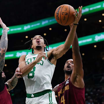 Oct 29, 2025; Boston, Massachusetts, USA; Boston Celtics forward Josh Minott (8) drives the ball against Cleveland Cavaliers center Evan Mobley (4) and guard Lonzo Ball (2) in the second quarter at TD Garden. Mandatory Credit: David Butler II-Imagn Images