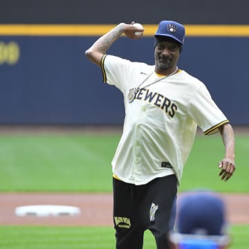 Jun 15, 2024; Milwaukee, Wisconsin, USA; Snoop Dog throws out the first pitch at the Cincinnati Reds and Milwaukee Brewers at American Family Field. Mandatory Credit: Michael McLoone-USA TODAY Sports