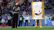 Pop-Tarts bowl mascot Strawberry entertains the fans during a time out in a 2023 game between the North Carolina State Wolfpack and Kansas State Wildcats at Camping World Stadium.