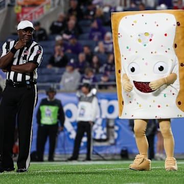 Pop-Tarts bowl mascot Strawberry entertains the fans during a time out in a 2023 game between the North Carolina State Wolfpack and Kansas State Wildcats at Camping World Stadium.