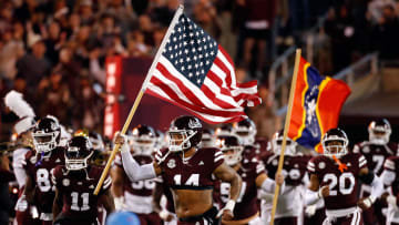 Nov 23, 2023; Starkville, Mississippi, USA; Mississippi State Bulldogs linebacker Nathaniel Watson (14) carries an American Flag onto the field prior to the game against the Mississippi Rebels at Davis Wade Stadium at Scott Field. Mandatory Credit: Petre Thomas-USA TODAY Sports