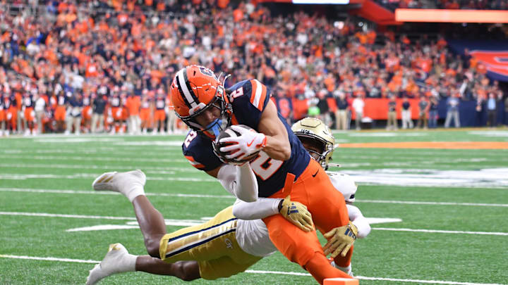 Sep 7, 2024; Syracuse, New York, USA; Syracuse Orange wide receiver Trebor Pena (2) scores a touchdown as Georgia Tech Yellow Jackets defensive back Ahmari Harvey (3) tries to stop him in the first quarter at JMA Wireless Dome. Mandatory Credit: Mark Konezny-Imagn Images