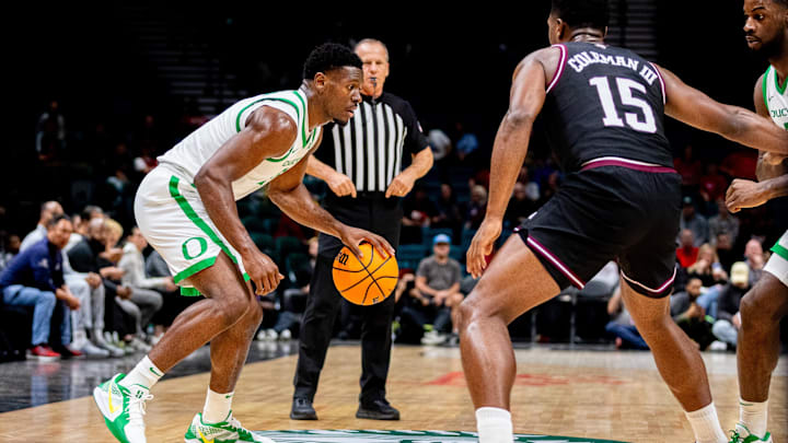 Nov 26, 2024; Las Vegas, Nevada, USA; Oregon Ducks guard TJ Bamba (5) dribbles against Texas A&M Aggies forward Henry Coleman III (15) during the first period at MGM Grand Garden Arena. Mandatory Credit: Jeffrey (Tyge) O'Donnell-Imagn Images