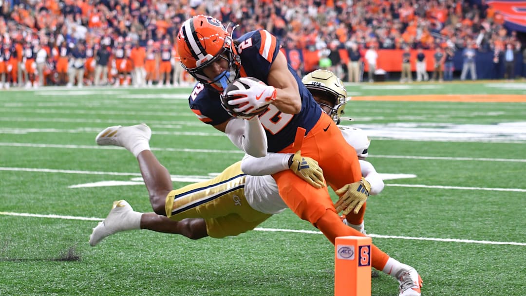 Sep 7, 2024; Syracuse, New York, USA; Syracuse Orange wide receiver Trebor Pena (2) scores a touchdown as Georgia Tech Yellow Jackets defensive back Ahmari Harvey (3) tries to stop him in the first quarter at JMA Wireless Dome. Mandatory Credit: Mark Konezny-Imagn Images