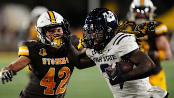 Oct 26, 2024; Laramie, Wyoming, USA; Utah State Aggies running back Rahsul Faison (3) runs against the Wyoming Cowboys during the second quarter at Jonah Field at War Memorial Stadium. Mandatory Credit: Troy Babbitt-Imagn Images
