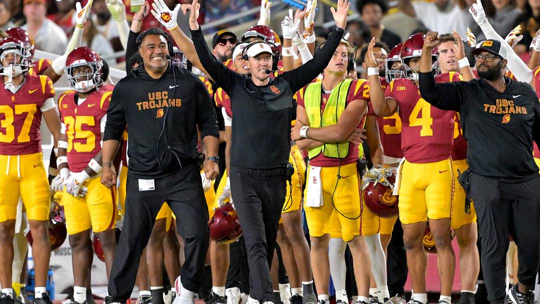 Oct 11, 2025; Los Angeles, California, USA;  USC Trojans head coach Lincoln Riley (wearing white visor) celebrates along with defensive end coach Shaun Nua after kicker Ryon Sayeri (48) hit a 54-yard field goal in the second half against the Michigan Wolverines at United Airlines Field at the Los Angeles Memorial Coliseum. Mandatory Credit: Jayne Kamin-Oncea-Imagn Images