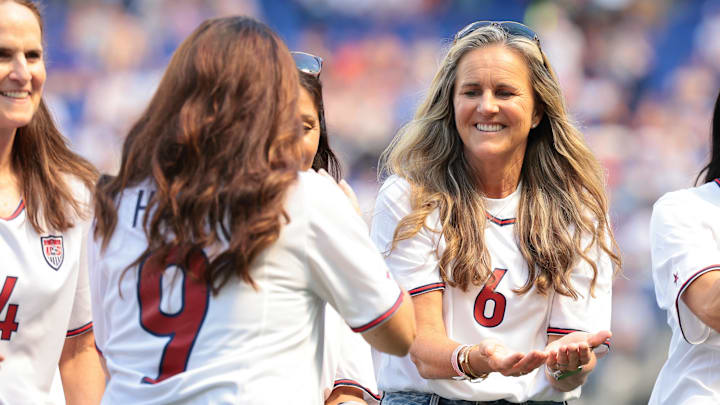 Jul 13, 2024; Harrison, New Jersey, USA; Mia Hamm (9) slaps hands with Brandi Chastain (6) while being honored with members of the the 1999 US Women's World Cup team during a pregame ceremony before the match at Red Bull Arena. Mandatory Credit: Vincent Carchietta-Imagn Images