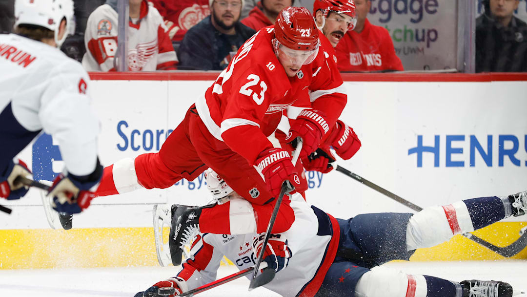 Jan 29, 2026; Detroit, Michigan, USA;  Detroit Red Wings left wing Lucas Raymond (23) is tripped up in the first period against the Washington Capitals at Little Caesars Arena. Mandatory Credit: Rick Osentoski-Imagn Images