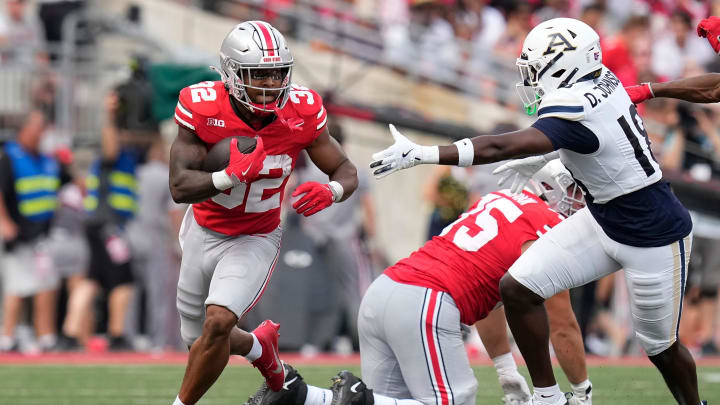 Aug 31, 2024; Columbus, OH, USA; Ohio State Buckeyes running back TreVeyon Henderson (32) runs past Akron Zips safety DiMarco Johnson (18) during the first half of the NCAA football game at Ohio Stadium.