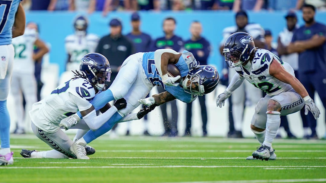 Tennessee Titans running back Tony Pollard (20) is tackled by Seattle Seahawks cornerback Riq Woolen (27) during the fourth quarter at Nissan Stadium in Nashville, Tenn., Sunday, Nov. 23, 2025.