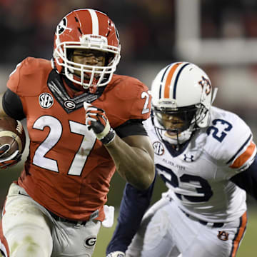 Nov 15, 2014; Athens, GA, USA; Georgia Bulldogs running back Nick Chubb (27) runs past Auburn Tigers defensive back Johnathan Ford (23) during the second half at Sanford Stadium. Georgia defeated Auburn 34-7. Mandatory Credit: Dale Zanine-Imagn Images