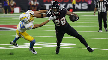 Jan 11, 2025; Houston, Texas, USA; -Los Angeles Chargers defensive back Deane Leonard (33) reaches for Houston Texans running back Joe Mixon (28) in the fourth quarter in an AFC wild card game at NRG Stadium. Mandatory Credit: Thomas Shea-Imagn Images