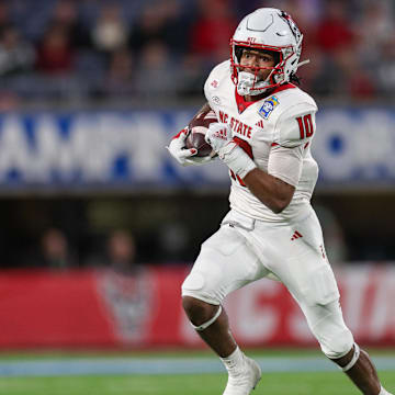 Dec 28, 2023; Orlando, FL, USA;  North Carolina State Wolfpack wide receiver Kevin Concepcion (10) runs with the ball against the Kansas State Wildcats in the second quarter during the Pop-Tarts bowl at Camping World Stadium. Mandatory Credit: Nathan Ray Seebeck-Imagn Images