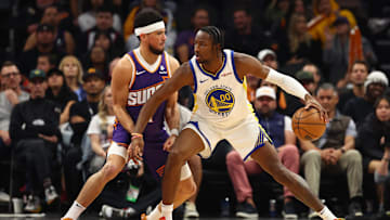 Dec 12, 2023; Phoenix, Arizona, USA; Golden State Warriors forward Jonathan Kuminga (00) against Phoenix Suns guard Devin Booker (1) at Footprint Center. Mandatory Credit: Mark J. Rebilas-Imagn Images