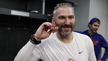 Apr 6, 2025; Elmont, New York, USA;  Washington Capitals left wing Alex Ovechkin (8) poses with the puck as he celebrates after scoring a goal in the 2nd period against the New York Islanders at UBS Arena. The goal is the 895th of Ovechkin’s career, breaking the NHL all-time career goals record previously held by Wayne Gretzky at UBS Arena. Mandatory Credit: Geoff Burke-Imagn Images