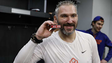 Apr 6, 2025; Elmont, New York, USA;  Washington Capitals left wing Alex Ovechkin (8) poses with the puck as he celebrates after scoring a goal in the 2nd period against the New York Islanders at UBS Arena. The goal is the 895th of Ovechkin’s career, breaking the NHL all-time career goals record previously held by Wayne Gretzky at UBS Arena. Mandatory Credit: Geoff Burke-Imagn Images