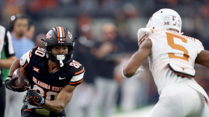 Oklahoma State's Brennan Presley (80) looks to get by Texas' Malik Muhammad (5) in the first half of the Big 12 Football Championship game between the Oklahoma State University Cowboys and the Texas Longhorns at the AT&T Stadium in Arlington, Texas, Saturday, Dec. 2, 2023.