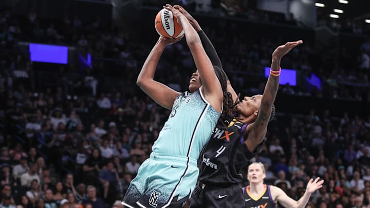Jul 25, 2025; Brooklyn, New York, USA;  New York Liberty center Jonquel Jones (35) is blocked from behind by Phoenix Mercury forward Natasha Mack (4) in the second quarter at Barclays Center. Mandatory Credit: Wendell Cruz-Imagn Images