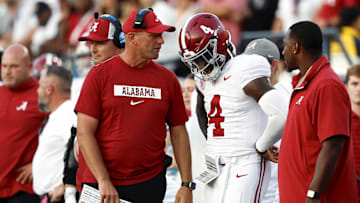 Alabama Crimson Tide head coach Kalen DeBoer talks with quarterback Jalen Milroe (4