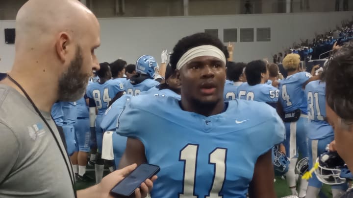 Frisco Emerson senior linebacker Agape Lawrence (middle) is interviewed following the Mavericks' 17-7 win against McKinney on August 29, 2024.