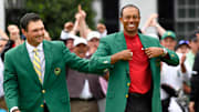 2018 winner Patrick Reed places the green jacket on 2019 winner Tiger Woods after the final round of The Masters golf tournament at Augusta National Golf Club.