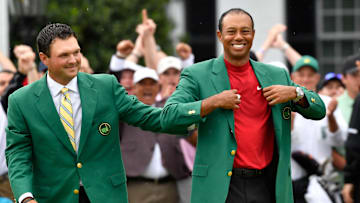2018 winner Patrick Reed places the green jacket on 2019 winner Tiger Woods after the final round of The Masters golf tournament at Augusta National Golf Club.