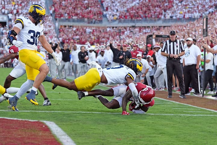 Oklahoma's Deion Burks scores a touchdown as Michigan's TJ Metcalf defends. 
