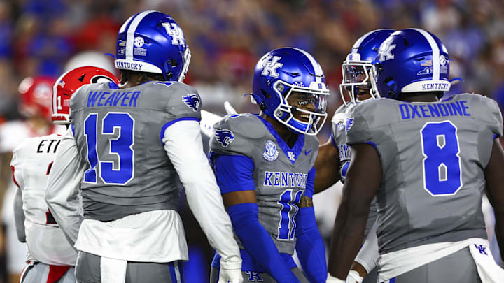 Sep 14, 2024; Lexington, Kentucky, USA; Kentucky Wildcats linebacker J.J. Weaver (13), defensive back Zion Childress (11) and defensive lineman Octavious Oxendine (8) celebrate after tackling Georgia Bulldogs running back Trevor Etienne (1) during the first quarter at Kroger Field. Mandatory Credit: Carter Skaggs-Imagn Images