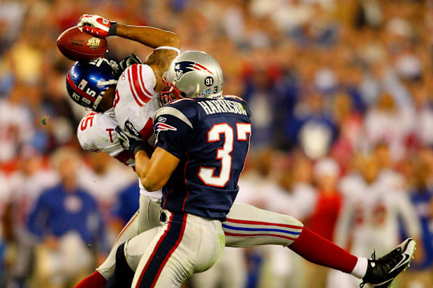Giants David Tyrei grabs a pass while he is in the paws of patriots Rodney Harrison in Super Bowl Xlii.