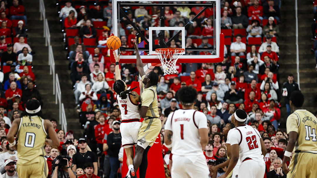 Jan 17, 2026; Raleigh, North Carolina, USA; NC State Wolfpack guard Alyn Breed (7) attempts a shot past Georgia Tech Yellow Jackets forward Baye Ndongo (11) during the second half of the game at Lenovo Center. Mandatory Credit: Jaylynn Nash-Imagn Images