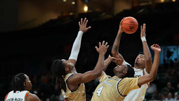 Dec 21, 2024; Coral Gables, Florida, USA; Miami Hurricanes center Lynn Kidd (1) grabs a rebound against Mount St. Mary's Mountaineers forward Dola Adebayo (4) and forward Terrell Ard Jr. (13) during the first half at Watsco Center. Mandatory Credit: Sam Navarro-Imagn Images