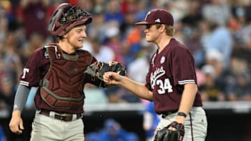 Jun 19, 2024; Omaha, NE, USA;  Texas A&M Aggies pitcher Josh Stewart (34) and catcher Jackson Appel (20) walk off the mound after the end of the sixth inning at Charles Schwab Field Omaha. Mandatory Credit: Steven Branscombe-USA TODAY Sports