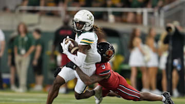 Nov 15, 2025; Waco, Texas, USA;  Baylor Bears wide receiver Ashtyn Hawkins (6) is tackled after the catch by Utah Utes cornerback Elijah Davis (9) during the first half at McLane Stadium. Mandatory Credit: Chris Jones-Imagn Images