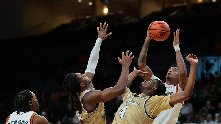 Dec 21, 2024; Coral Gables, Florida, USA; Miami Hurricanes center Lynn Kidd (1) grabs a rebound against Mount St. Mary's Mountaineers forward Dola Adebayo (4) and forward Terrell Ard Jr. (13) during the first half at Watsco Center. Mandatory Credit: Sam Navarro-Imagn Images