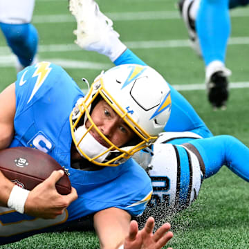 Sep 15, 2024; Charlotte, North Carolina, USA;  Los Angeles Chargers quarterback Justin Herbert (10) is tackled by Carolina Panthers safety Xavier Woods (25) and safety Jordan Fuller (20) in the second quarter at Bank of America Stadium. Mandatory Credit: Bob Donnan-Imagn Images