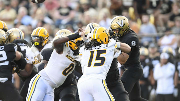 Sep 30, 2023; Nashville, Tennessee, USA;  Vanderbilt Commodores quarterback Ken Seals (8) throws a wobbly pass after being hit by Missouri Tigers defensive lineman Jayden Jernigan (0) and defensive lineman Johnny Walker Jr. (15) during the second half at FirstBank Stadium. Mandatory Credit: Steve Roberts-Imagn Images