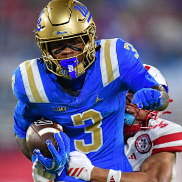 Nov 8, 2025; Pasadena, California, USA; UCLA Bruins wide receiver Kwazi Gilmer (3) runs the ball ahead of Nebraska Cornhuskers defensive back Donovan Jones (37) during the first half at the Rose Bowl. Mandatory Credit: Gary A. Vasquez-Imagn Images