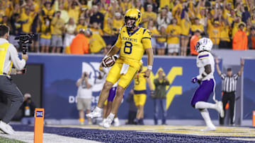 Sep 7, 2024; Morgantown, West Virginia, USA; West Virginia Mountaineers quarterback Nicco Marchiol (8) runs the ball for a touchdown during the fourth quarter against the Albany Great Danes at Mountaineer Field at Milan Puskar Stadium. Mandatory Credit: Ben Queen-Imagn Images