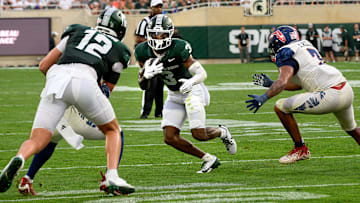 Aug 30, 2024; East Lansing, Michigan, USA;  Michigan State Spartans wide receiver Montorie Foster Jr. (3) looks for an opening while running away from Florida Atlantic Owls linebacker Eddie Williams (3) in the first quarter at Spartan Stadium. Mandatory Credit: Dale Young-Imagn Images