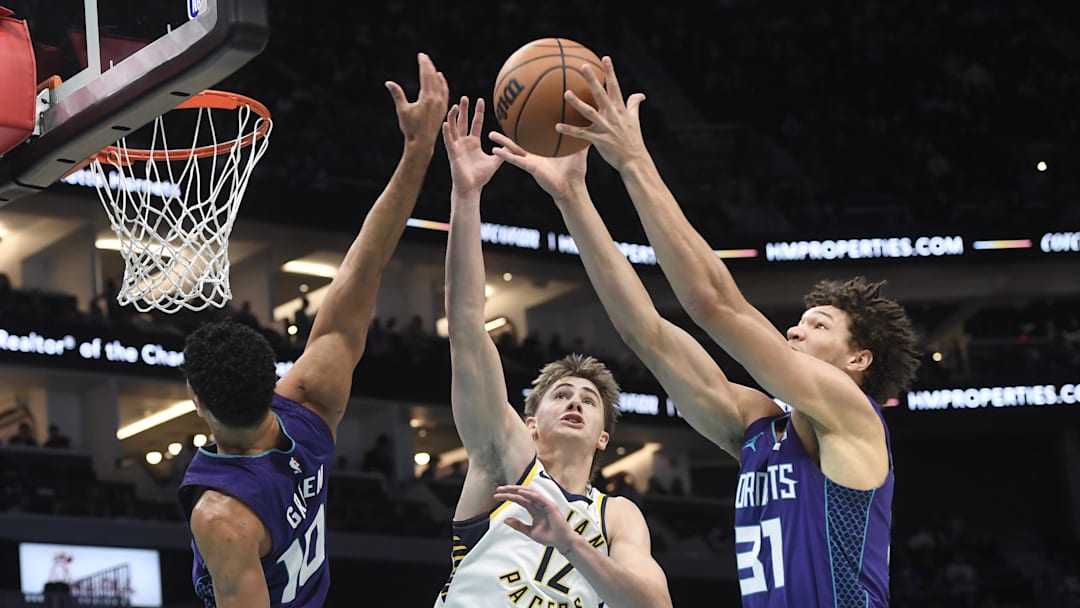 Jan 8, 2026; Charlotte, North Carolina, USA;  Indiana Pacers guard Johnny Furphy (12), Charlotte Hornets guard Josh Green (10) and forward Tidjane Salaun (31) fight for a rebound during the second half at the Spectrum Center. Mandatory Credit: Sam Sharpe-Imagn Images