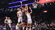 Jan 8, 2025; Brooklyn, New York, USA;  Brooklyn Nets forward Tosan Evbuomwan (12) looks to drive past Detroit Pistons forward Bobi Klintman (34) and guard Wendell Moore Jr. (14) in the fourth quarter at Barclays Center. Mandatory Credit: Wendell Cruz-Imagn Images