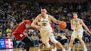 Michigan Wolverines center Vladislav Goldin (50) drives the lane against Rutgers Scarlet Knights defense during the first half of the NCAA basketball game at Crisler Arena in Ann Arbor, Mich., Thursday, February 27 2025.