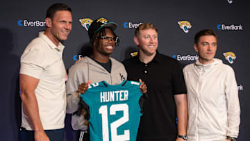 Apr 25, 2025; Jacksonville, FL, USA; Jacksonville Jaguars first round draft pick Travis Hunter poses for a photo with executive vice president of football operations Tony Boselli, head coach Liam Coen, and general manager James Gladstone, during a press conference at Miller Electric Center. Mandatory Credit: Travis Register-Imagn Images