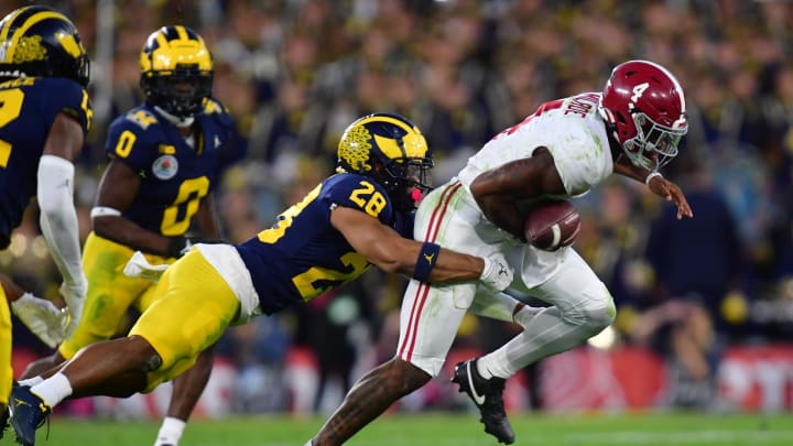 Jan 1, 2024; Pasadena, CA, USA; Michigan Wolverines defensive back Quinten Johnson (28) forces a fumble against Alabama Crimson Tide quarterback Jalen Milroe (4) in the fourth quarter in the 2024 Rose Bowl college football playoff semifinal game at Rose Bowl. Mandatory Credit: Gary A. Vasquez-USA TODAY Sports