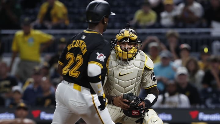 Aug 7, 2024; Pittsburgh, Pennsylvania, USA;  San Diego Padres catcher Luis Campusano (12) tags Pittsburgh Pirates designated hitter Andrew McCutchen (22) out at home plate during the tenth inning at PNC Park. San Diego won 9-8 in ten innings. Mandatory Credit: Charles LeClaire-Imagn Images